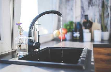 Flowing water from a kitchen tap fresh for drinking thanks to the water softener installed by RJ Parins Plumbing & Heating in Green Bay WI.