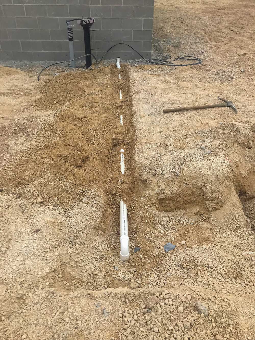 Plumbing line leading to building installed by RJ Parins Plumbing & Heating in Green Bay WI.