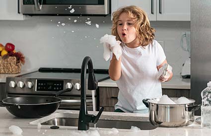 Child blowing soap bubbles at a sink installed in a residential home by RJ Parins Plumbing & Heating in Green Bay WI.